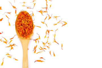 A pile of Dried Safflower petals herb Tea and a wooden spoon. isolated on a white background - obrazy, fototapety, plakaty