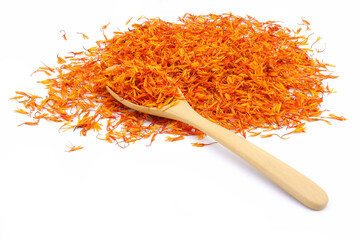 A pile of Dried Safflower petals herb Tea and a wooden spoon. isolated on a white background