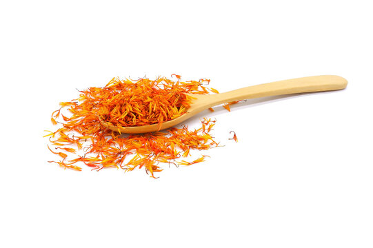 A pile of Dried Safflower petals herb Tea and a wooden spoon. isolated on a white background