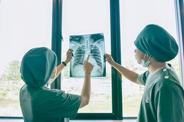 Doctor checking examining chest x-ray film of patient at ward hospital