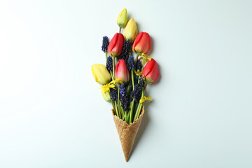 Waffle cone with flowers on white background