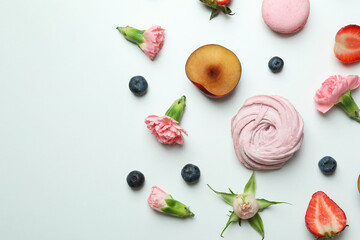 Concept of tasty macaroons and marshmallows on white background