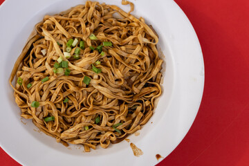 Noodles are served in bowl and mixed in aromatic dark soy sauce and pork oil