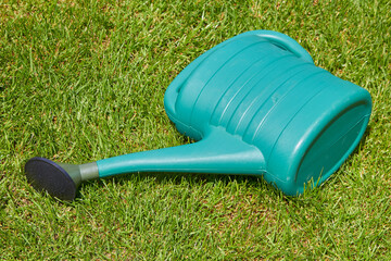 garden watering can,watering can lies on the grass in summer