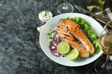 Concept of tasty eating with grilled salmon on black smokey table