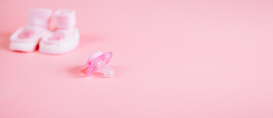 Orthodontic pacifier in pink color, isolated on a pink background. Shows signs of use. Space for text on a dummy background