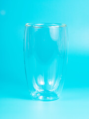 Empty glass with double walls on blue background
