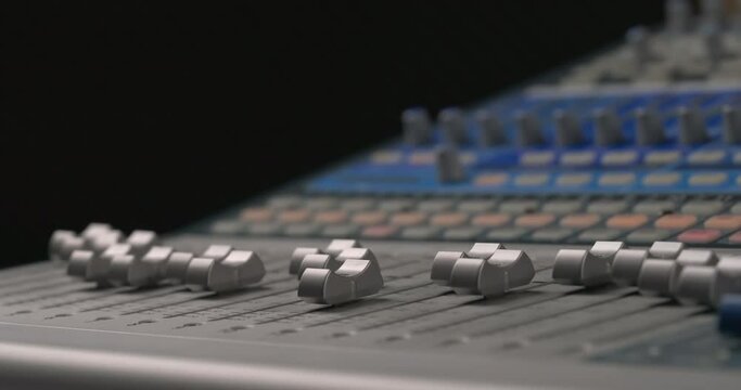 Sound engineer's hand using music mixer with editing tools. Professional music console in recording studio