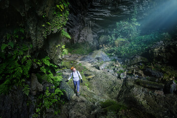Woman traveler explores beautiful Hang Tien Cave in Phong Nha Ke National Park. Vietnam
