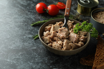 Concept of tasty eating with canned tuna on black smokey background