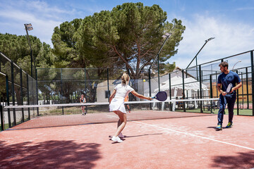 padel tennis players play on an outdoor court