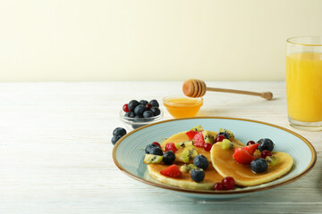 Concept of delicious dessert with pancakes on white wooden table