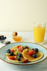 Concept of delicious dessert with pancakes on white wooden table