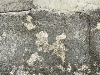 Different textures and colourations of cracked floor concrete.