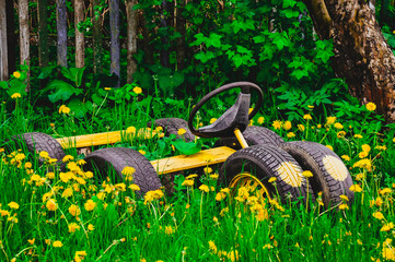 Children's toy car made of car tires in the green grass. With your own hands.