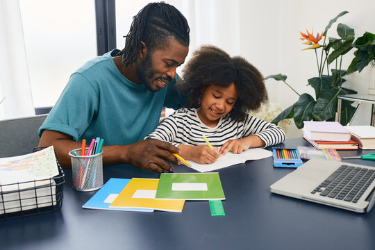 Father Helps His Daughter Doing School Homework At Home. Father's Day, Happy Dad And Schoolgirl, Happy Family