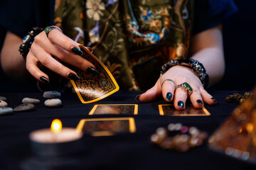 Cartomancy. Fortune-telling on cards. A fortune teller lays out Tarot cards. Close up of hands. The...