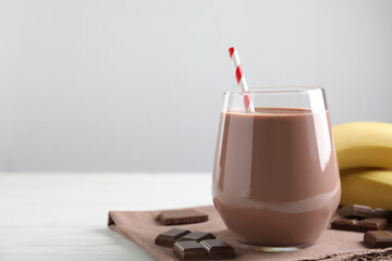 Fresh yummy chocolate milk on white wooden table. Space for text