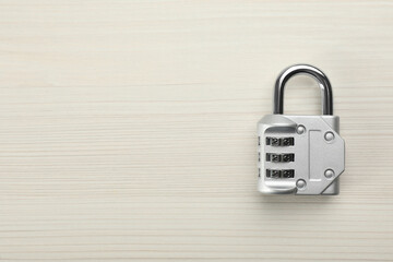 Modern combination lock on white wooden table, top view. Space for text