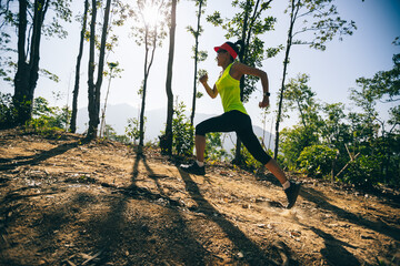 Fitness woman trail runner running on sunrise tropical forest mountain peak