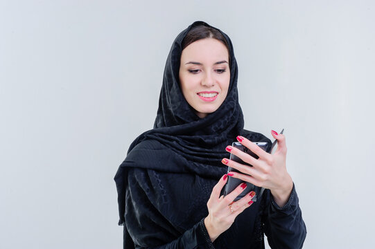 Arabic way dressed woman taking selfie using mobile camera