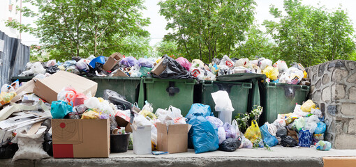 Overloaded dumpster, full garbage container, household garbage bin, trash can, heap of unsorted...