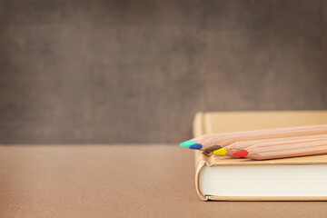 Back to school and education concept. Coloful wooden pencils on a book near the blackboard and...