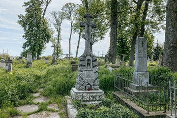 Ukrainian gravestone on old abandoned Polish city cemetery in Zhydachiv, Lviv region, Ukraine. Weathered stone tombstone on abandoned graveyard. Selective focus