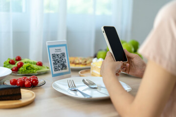 Women use phone to scan qr code to select food menu and collect points. Scan to get discounts or...