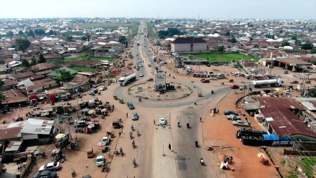 Road traffic in Minna, Nigeria's Niger State with a view of the traffic and city - push in descending aerial view