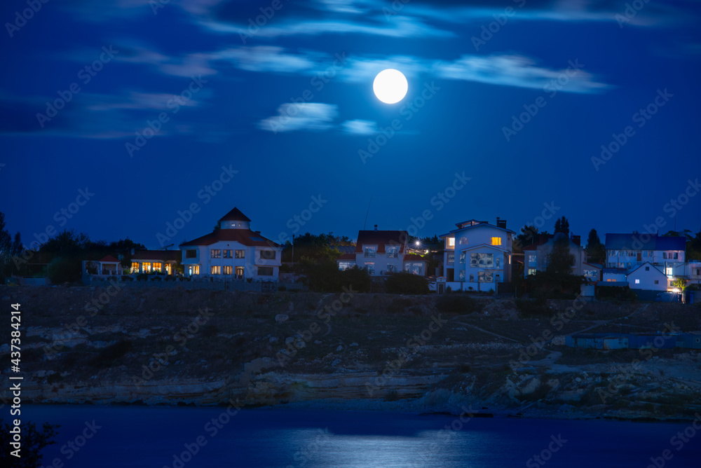 Canvas Prints Moon over river and town with night sky and clouds