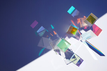 Abstract background with glass geometric figures prisms with light diffraction of spectrum colors and complex reflection.