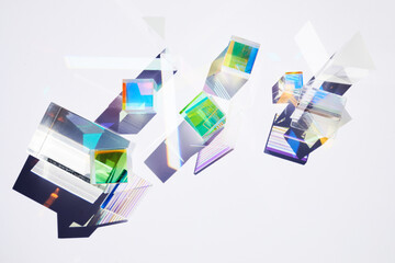 Abstract background with glass geometric figures prisms with light diffraction of spectrum colors and complex reflection.