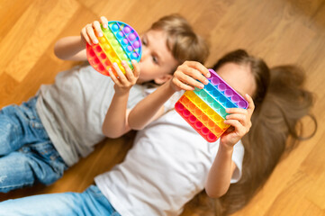 anti stress sensory pop it toys in a children's hands. a little happy kids plays with a simple...