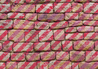 Bandes rouges sur mur de pierres 