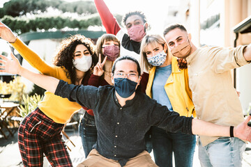 Group of tourists wearing protective face mask on city street smiling at camera - New normal concept with young people having fun on vacation - Reopening holidays concept