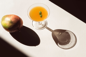 Summer stationery still life scene with mango and mango juice and  trendy, dark, long shadows