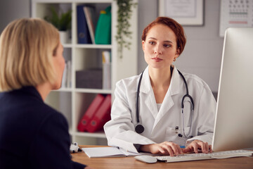 Female Doctor In White Coat Having Meeting With Mature Woman Patient In Office