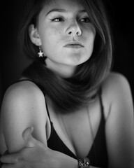 A beautiful young woman with red curly long hair posing at studio. Beauty woman monochrome portrate. Black-white art photography.