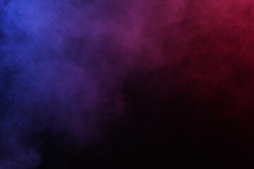 Artificial magic smoke in red-blue light on black background