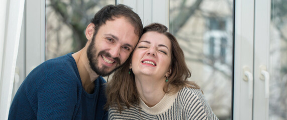 Romantic couple looking out of the window. Quarantine at home.