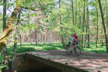Kobieta i mężczyzna w średnim wieku na leśnej wycieczce rowerowej.