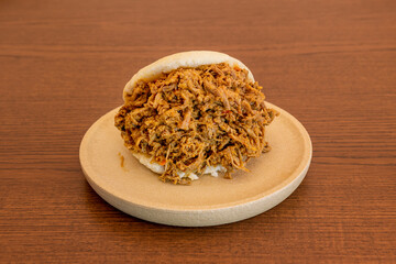arepa overflowing with shredded meat with a classic Venezuelan recipe on a round resin plate