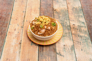 Latin recipe of arroz chaufa with fresh vegetables, scrambled eggs and fried chicken
