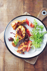 Grilled chicken pieces with fresh salad. Wooden background. Top view. 