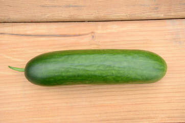 closeup ripe green cucumber on the wooden background.