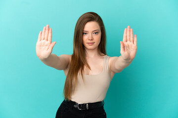 Teenager girl over isolated blue background making stop gesture and disappointed