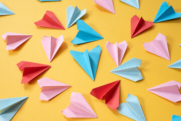 colorful origami paper airplanes on yellow colored background. childhood,freedom, art origami and...