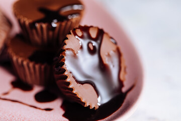 Chocolate pralines with flowers in background on a pink plate 