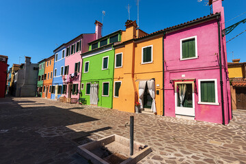 Fototapeta na wymiar Beautiful multi colored houses in Burano island in a sunny spring day. Venice lagoon, UNESCO world heritage site, Veneto, Italy, southern Europe.